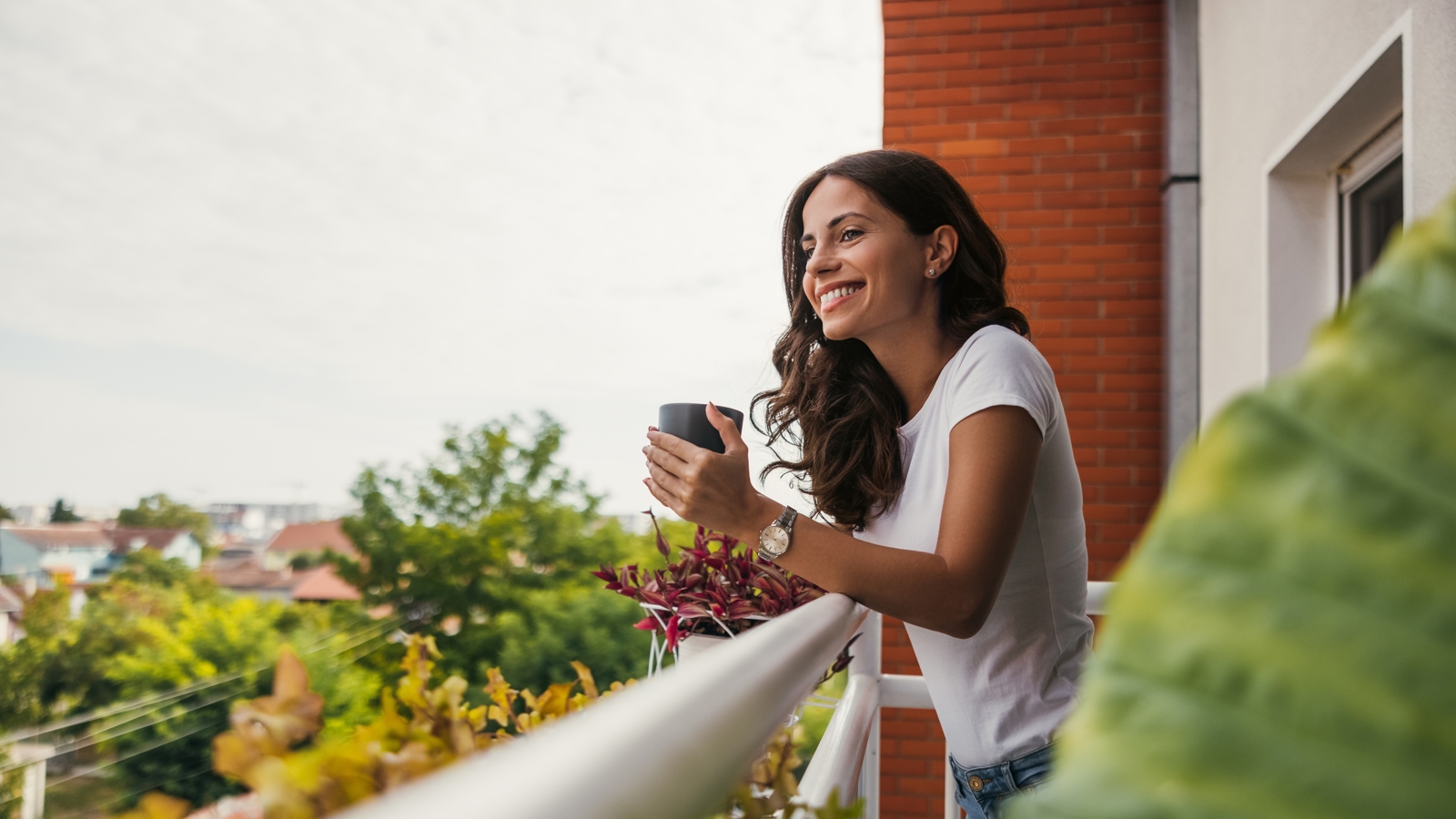 A woman holding a mug on a balcony