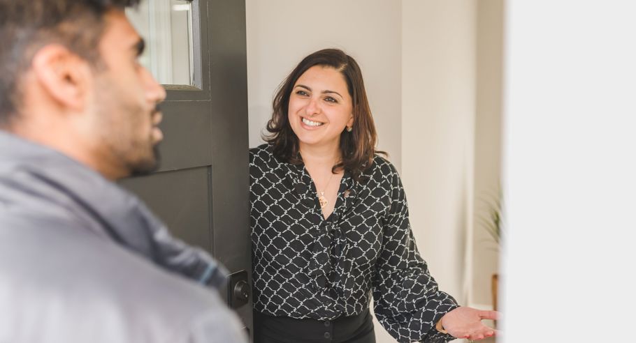 A woman opening a door for a man